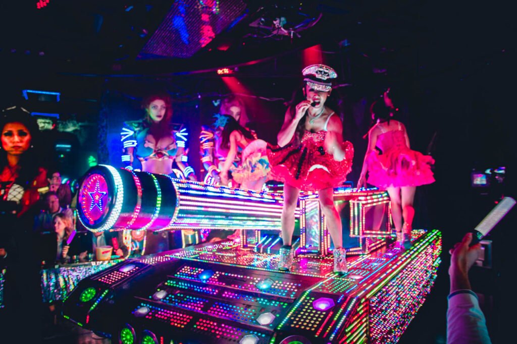 Woman performer riding a neon tank at Robot Restaurant